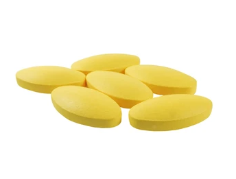 Tadalafil yellow pills sitting on a white background